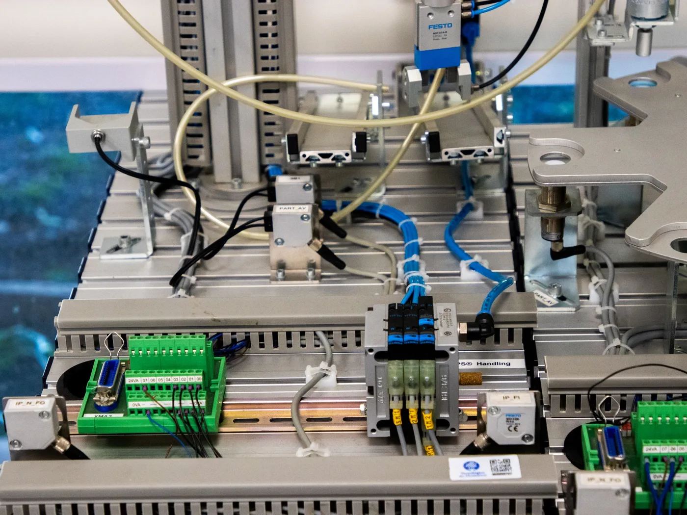 Industrial automation rig combining sensors, terminal blocks, pneumatics and control electronics
